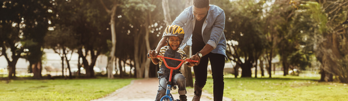 Dad teaching son to ride a bike
