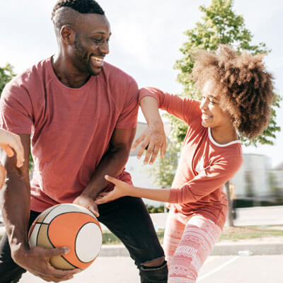 Dad and daughter playing basketball