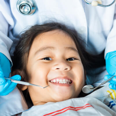 little girl smiling on dental chair