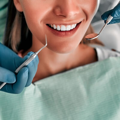 closeup of dentist hands examining smile