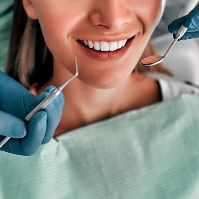 A woman smiling while having her teeth cleaned.