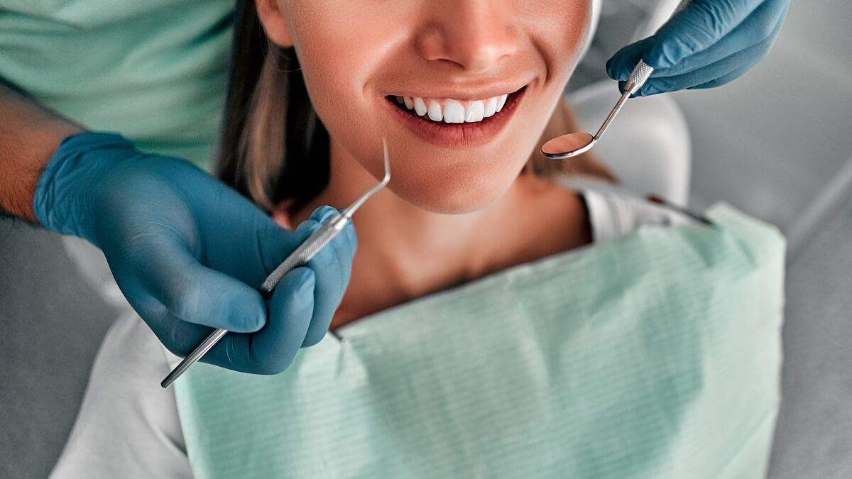 dental tools by woman's mouth