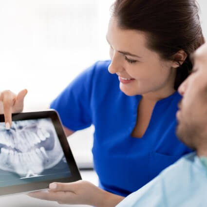 Dentist showing dental xray to patient