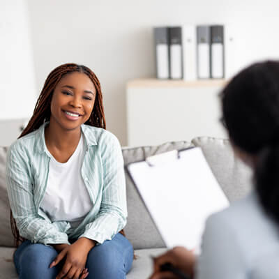 woman on couch smiling during consultation