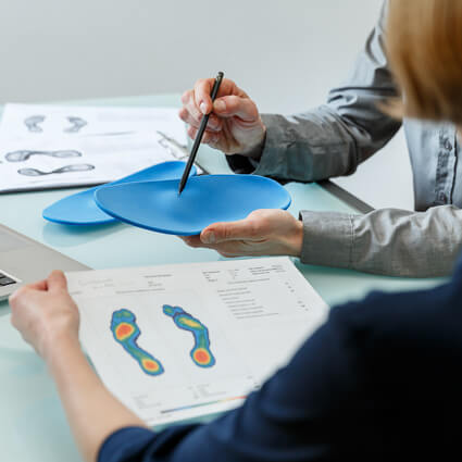 doctor pointing at orthotic insert during a consultation
