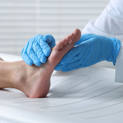 doctor with blue gloves examining the foot