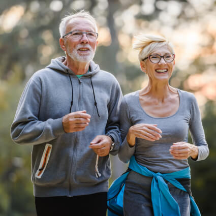 older man and woman jogging outdoors