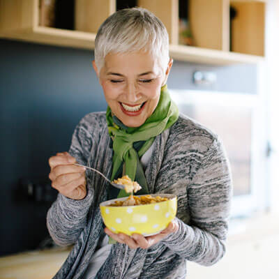 woman smiling eating nutritious breakfast