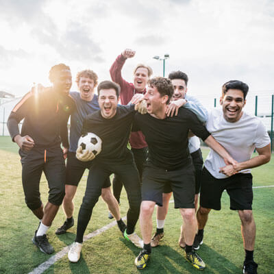 A soccer team celebrating on the field after a victory.