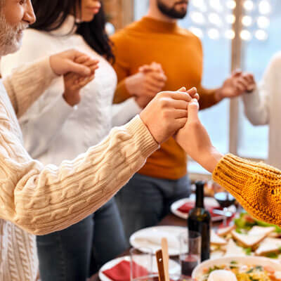 family holding hands at holiday dinner