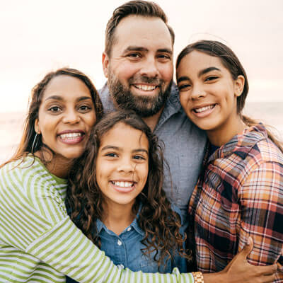 family hugging on beach