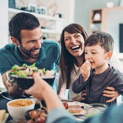 Family laughing while eating dinner