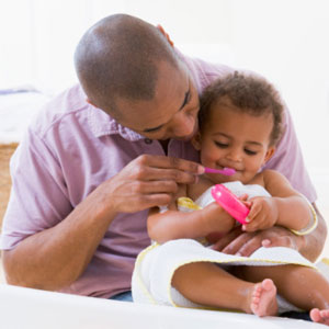 Dad brushing child's teeth