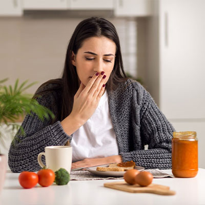 female having breakfast with stomach pain