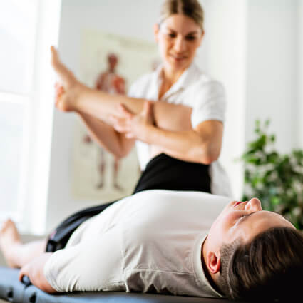 Female practitioner adjusting man in black shorts leg