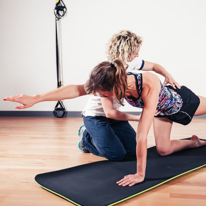 Physical therapist assisting a patient during a workout stretch
