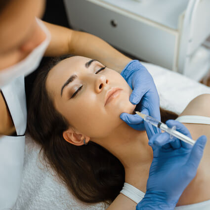female weating gloves injecting womans chin