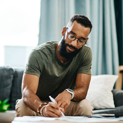 man filling out paperwork on a table