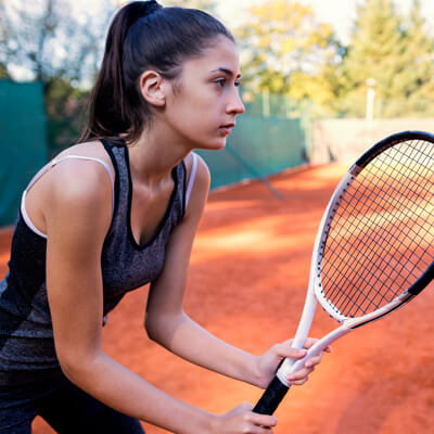 Girl swinging tennis racket