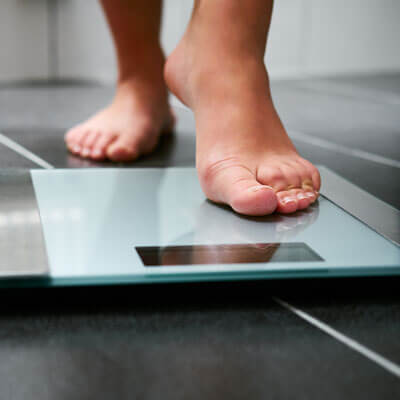 Woman stepping on scale