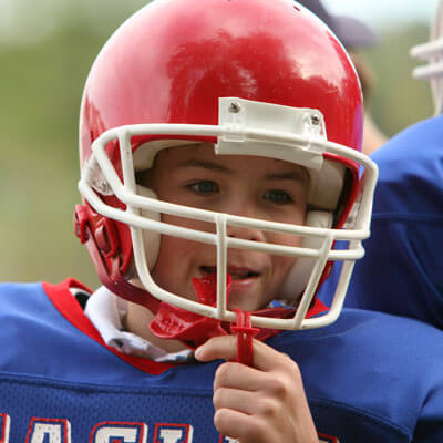 boy with football helmet and mouthguard