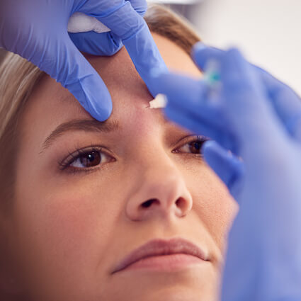 Woman receiving forehead filler treatment
