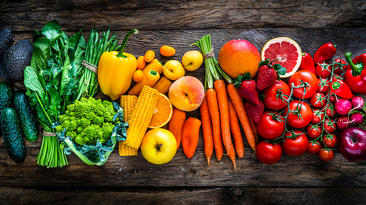 Rainbow of fresh fruit and veggies on table