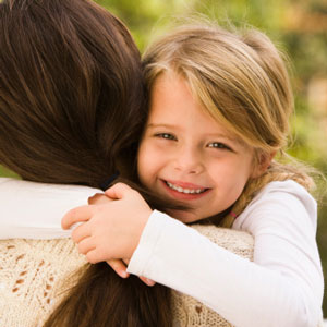 little girl hugging mom and smiling