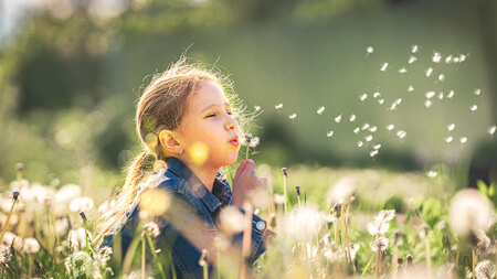 girl blowing flower