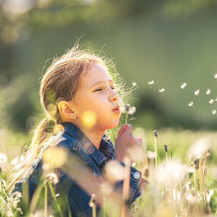 Girl blowing flower