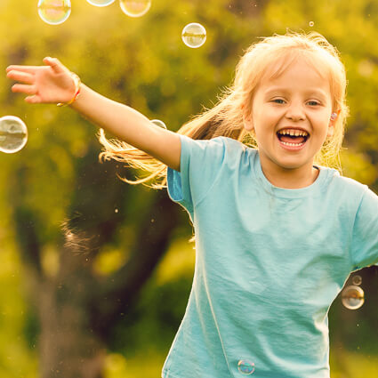 Young girl catching bubbles