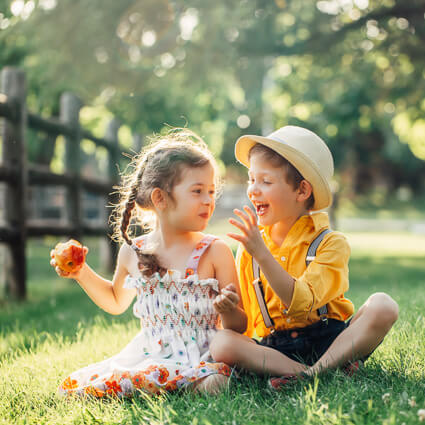 Girl eating apple next to boy