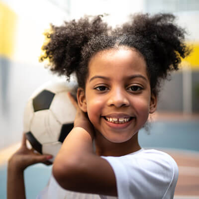 smiling kid holding soccer ball