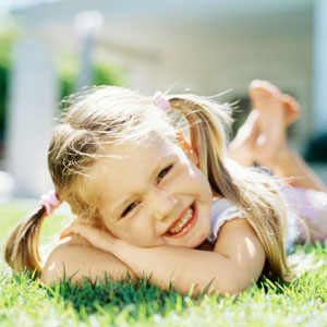 girl in piggytails laying on grass