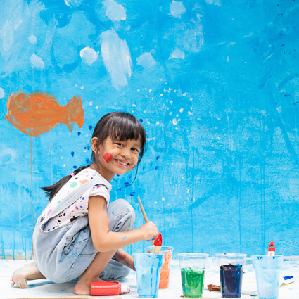 Little girl painting a wall