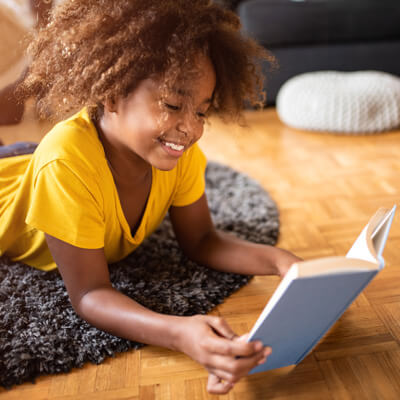 girl reading on living room floor