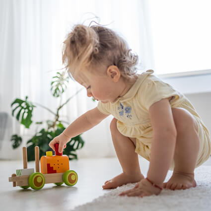 toddler playing with truck on the carpet