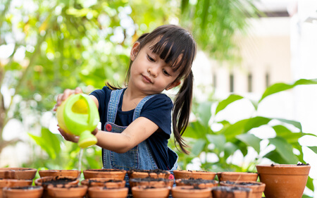 Little girl watering plants