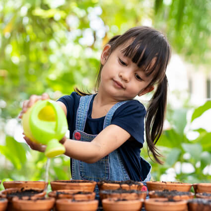 Little girl watering plants
