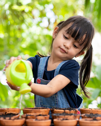Little girl watering plants