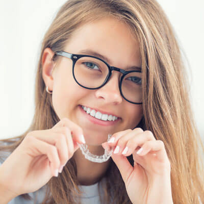 girl with glasses putting in aligner
