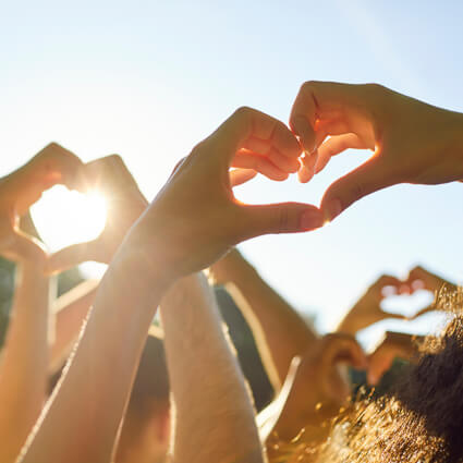 people making heart shapes with their hands