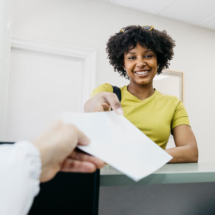 smiling woman being handed paperwork