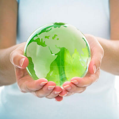 hands holding green glass globe