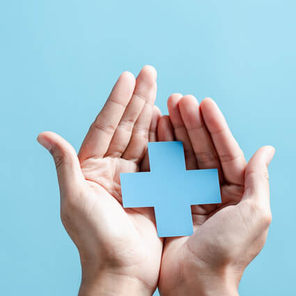 person holding a blue cross in their palms