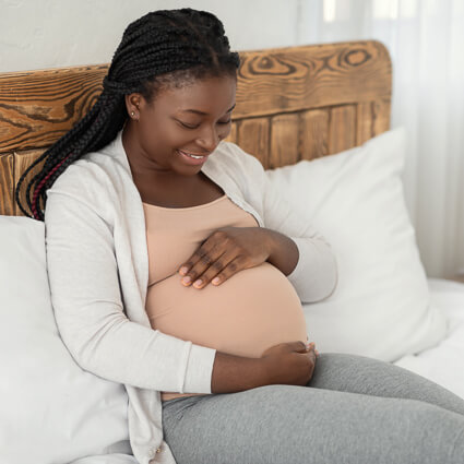 pregnant woman looking down at her stomach