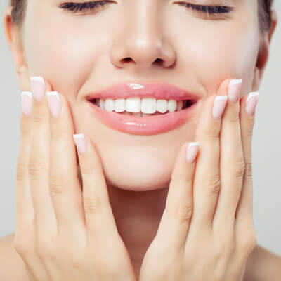 smiling woman with her hands on her cheeks