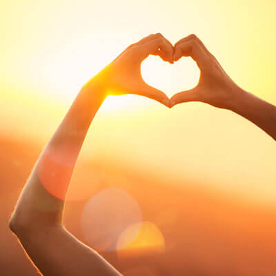 person making heart shape with hands