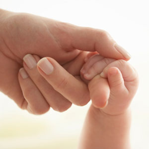 Mom holding baby's hand.