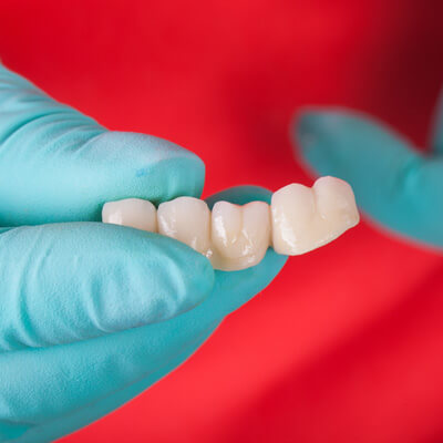 person holding dental bridge